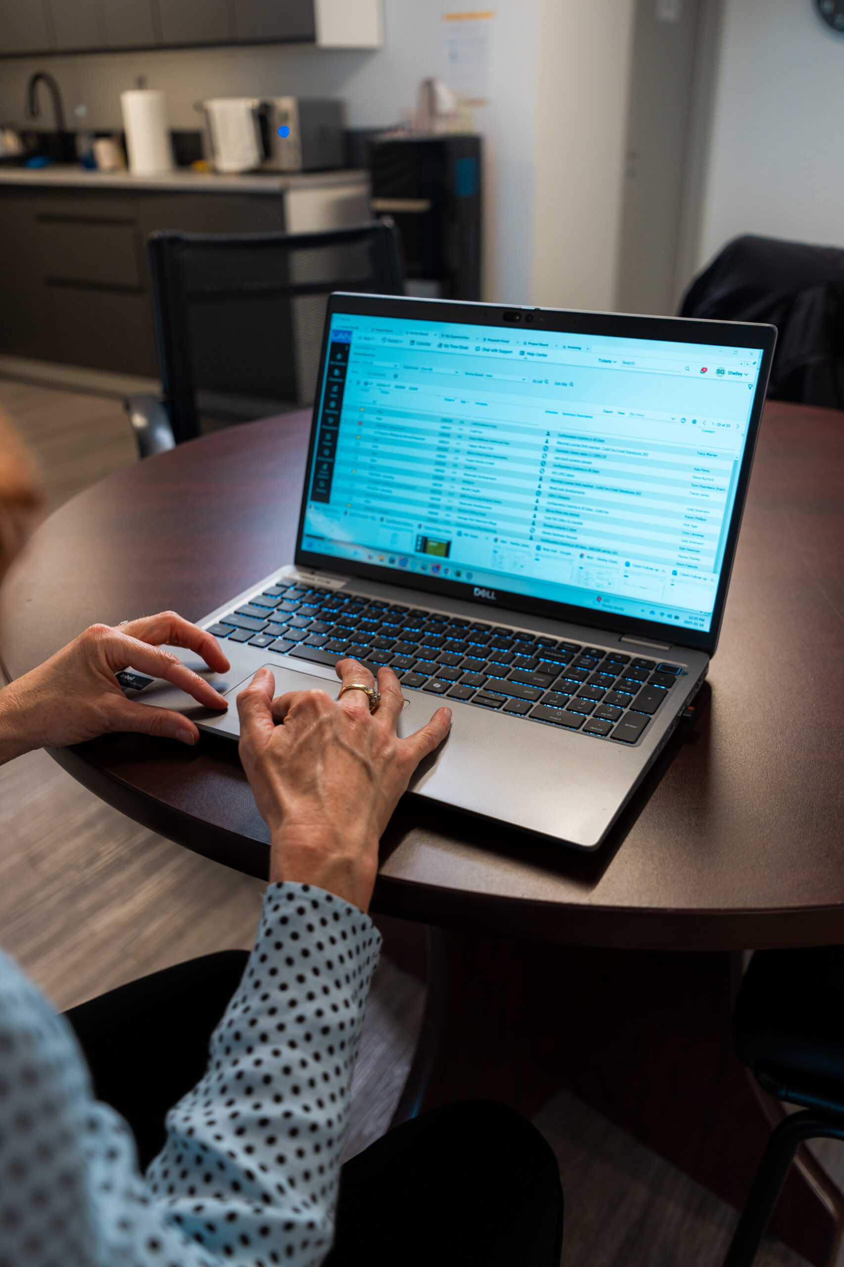 Close-up of a woman’s hands typing on a laptop, symbolizing the human side of phishing and social engineering risks in business